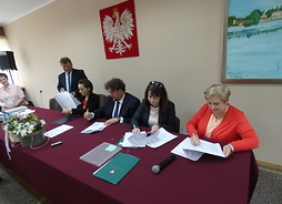 Przy stole podpisy składaj: wicemarszałek Janina Ewa Orzełowska, członek zarządu Elżbieta Lanc, Burmistrz Mariusz Kucewicz
