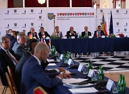 Widok na stół prezydialny, przy którym siedzą marszałkowie i goście konwentu