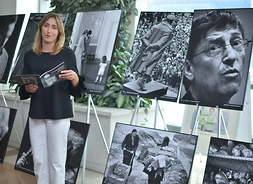 Marta Milewska przemawia stojąc obok wyeksponowanych fotografii