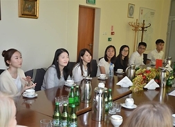 Grupa zagranicznych studentów siedziąca przy stole