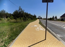 Ścieżka rowerowa i jednocześnie chodnik ułożona z kostki brukowej, biegnąca wzdłuż jezdni