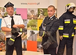 dwaj strażacy przymierzają rękawice strażackie