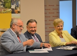 Marszałek i członek zarządu Elżbieta Lanc podpisują umowę z beneficjentem
