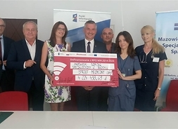 Członek zarządu województwa Rafał Rajkowski i przedstawiciele szpitala w Radomiu trzymają symboliczny czek