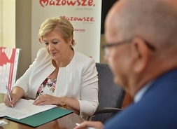 Zdjęcie przedstawia członka zarządu województwa Elżbietę Lanc podpisującą umowę