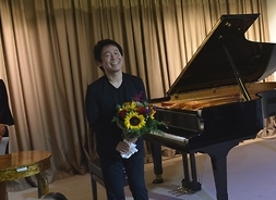 owacje po koncercie zebrał japoński pianistaTakashi Yamamoto. w tle prowadząca koncert Olga Bończyk