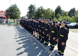 Na zdjęciu widać Młodzieżowe Drużyny Pożarnicze i członków jednostki OSP Olszyc Szlachecki stojących w dwuszeregu