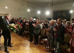 Pianista z kwiatami stoi przed publicznością