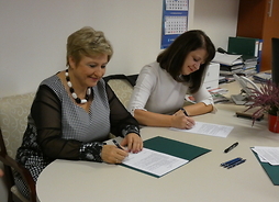 przy stole siedzą wicemarszałek Janina Ewa Orzełowska, członek zarządu Elżbieta Lanc, podpisują umowy