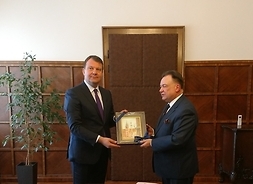 Marszałek Adam Struzik wręcza przewodniczącemu prowincji pamiątkowy obraz z wizerunkiem starówki w Warszawie