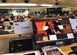 sala obrad, na pierwszym planie ekran, na którym widać jak przemawiagłówny europejski negocjator w sprawie wystąpienia Zjednoczonego Królestwa z Unii Europejskiej – Michel Barnier