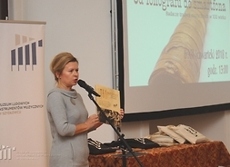 dr Aneta Oborny, dyrektor szydłowieckiego  muzeum trzyma w ręku książkę o polskich etnomuzykologach Jadwidze i Marianie Sobieskich