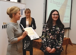 dr Aneta Oborny, dyrektor muzeum trzyma w ręku dyplom z wyróżnieniem dla laureatki konkursu, Julii Bialik za film „Urodziny”