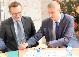 Czek podpisuje burmistrz Glinojecka Łukasz Kapczyński, obok siedzi prezydent Ciechanowa