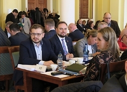 Za stołem obrad siedzą radni Krzysztof Strzałkowski, Bartosz Wiśniakowski i Katarzyna Bornowska