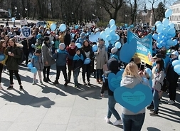 Niebieski Marsz - dziesiątki uczestników, dzieci i młodzież z placówek szkolnych i przedszkolnych z wychowawcami - niosą niebieskie balony, kartonowe niebieskie serca i emblematy swoich szkół i przedszkoli.