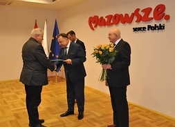 Tadeusz Skoczek przyjmuje z rąk marszałka dyplom z gratulacjami