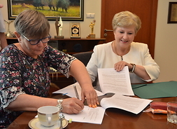 członek zarządu województwa Elżbieta Lanc oraz jedna z beneficjentek podspują umowy
