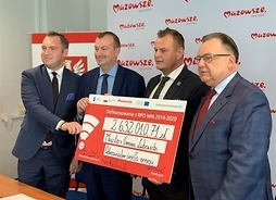 Przedstawiciele samorządu województwa mazowieckiego oraz burmistrz Lubowidza pozują do pamiątkowej fotografii z symbolicznym czekiem