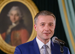Przewodniczący Sejmiku Województwa Mazowieckiego Ludwik Rakowski stoi na scenie, wita gości wydarzenia