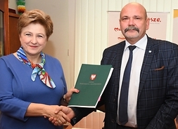 Członek zarządu województwa mazowieckiego Elżbieta Lanc i dyrektor Regionalnego Zarządu Gospodarki Wodnej w Warszawie Robert Chciuk trzymają w ręku symboliczny czek i podpisaną umowę