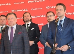 Na pierwszym planie stoją Adam Struzik i Rafał Trzaskowski, za nimi stoi trzech uczestników konferencji.