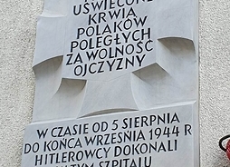 tablica pamiątkowa upamiętniająca ofiary wolskiej rzezi, napis brzmi: miejsce uświęcone krwią Polaków poległych za wolność Ojczyzny