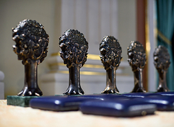 Pięć statuetek tej nagrody - stoją w rzędzie na blacie stołu.
