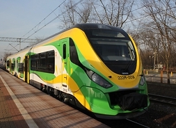 na torze stoi pociąg w barwach zółto zielono białych