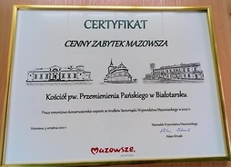 Certyfikat za szkłem oprawiony w ramkę.