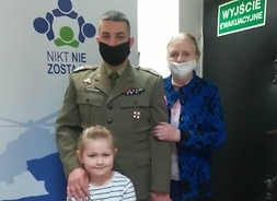 Radna Jadwiga Zakrzewska z mężczyzną w mundurze wojskowym oraz dziewczynką pozują do wspólnej fotografii.