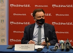 Marszałek na tle ściany z logo Mazowsza