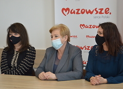 Przy stole siedzą członkowie zarządu Elżbieta Lanc i Janina Ewa Orzełowska oraz radna województwa