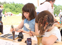 Próby pisania przez dzieci piórem i atramentem podczas Pikniku historycznego w Lipkowie
