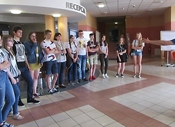 Grupa uczniów stoi przed przewodnikiem.