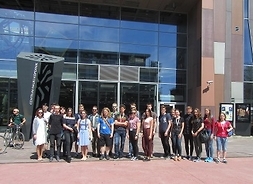 Grupa młodzieży stoi przed szklaną ścianą wejścia do Centrum Nauki Kopernik.
