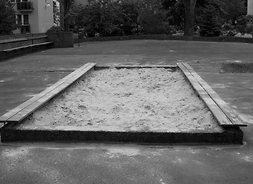 czarno-białe zdjęcie piaskownicy na miejskim podwórku