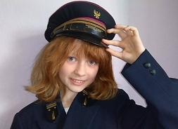 Dziecko ubrane w replikę munduru kolejarza z efektowną czapką