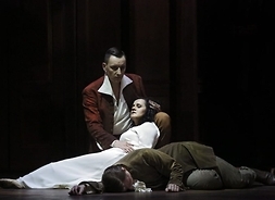 Troje aktorów – leżący mężczyzna. Drugi trzyma na kolanach kobietę w białej sukni z zamkniętymi oczami