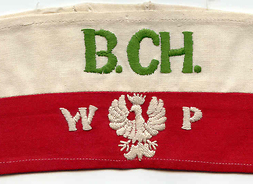 Bawełniana opaska w narodowych barwach z wyhaftowanymi literami B.Ch. i W.P oraz godłem