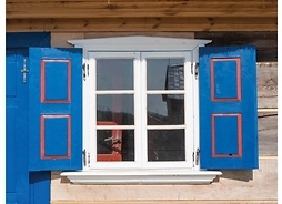 Plakat zapraszający na imprezę ze zdjęciem charakterystycznego okna z okiennicami i okapem w ścianie domu typu olenderskiego