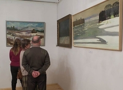 Grupa osób oglądająca wystawę obrazów