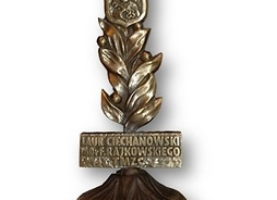 Fotografia nagrody – statuetka z brązu w kształcie kłosa z wkomponowanym herbem Ciechanowa i tabliczką „Laur ciechanowski im. dr F. Rajkowskiego”