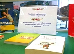 Zdjęcie przedstawia stół z wyłożonymi książkami o szczęściu