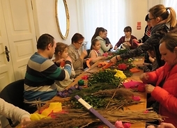 Zdjęcie przedstawia grupę dzieci podczas warsztatów z układania stroików