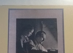Zdjęcie przedstawia fotografię, na której uwidoczniony jest Zbigniew Lengren pracujący przy biurku, za jego plecami stoi córka Katarzyna