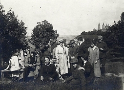 Zdjęcie archiwalne, przedstawiające grupę osób pozujących do wspólnej fotografii. Zdjęcie w plenerze.