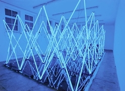 Instalacja artystyczna. Świecące neony w kształcie trójkątów nachodzących na siebie.