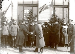Zdjęcie archiwalne dokumentujące wizytę marszałka Piłsudskiego w Siedlcach. Grupa osób wita marszałka. Jeden z mężczyzn podaje mu dłoń na przywitanie.