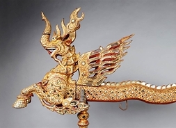 Wizerunek smoka ze rozpostartymi skrzydłami, wykonany z metalu.